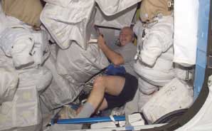 El astronauta John Phillips trabaja con cajas de carga dentro de la esclusa de aire Quest. (Foto: NASA)